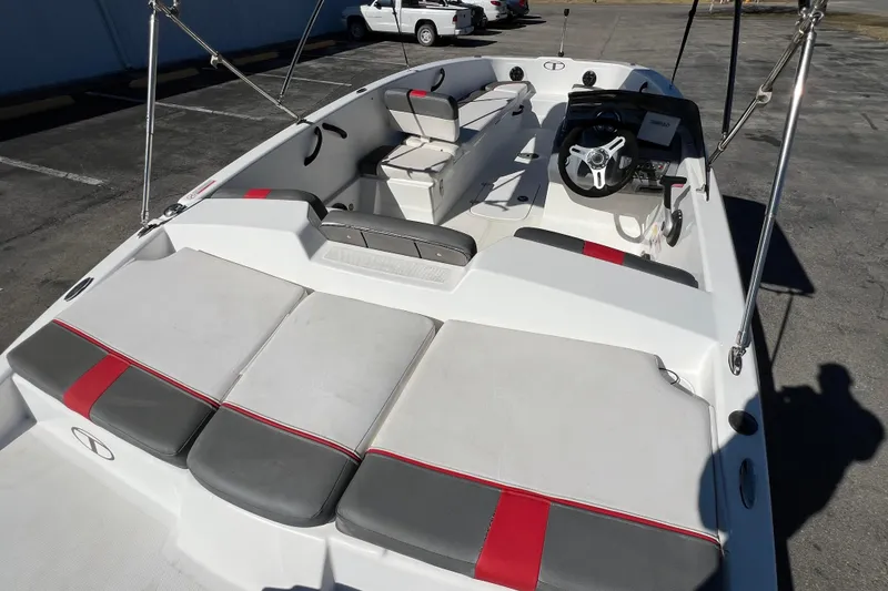 Slide: The Image of 2022 Tahoe T18 boat interior with seating and steering wheel, parked on pavement. - 9
