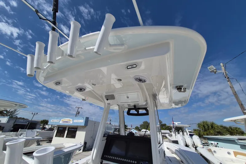 Slide: The Image of 2026 Regulator 31 boat with rod holders and electronics under a clear blue sky. - 10