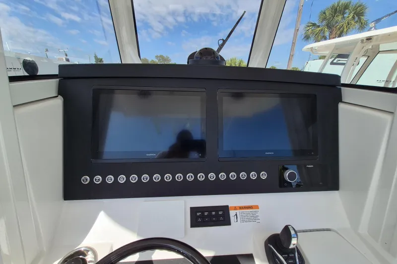 Slide: The Image of 2026 Regulator 31 boat dashboard with dual Garmin displays and control panel. - 11
