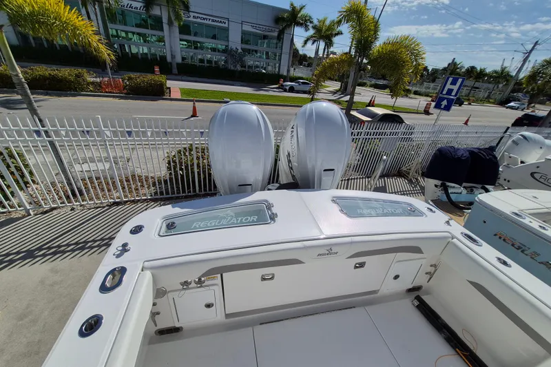 Slide: The Image of 2026 Regulator 31 boat with dual engines, parked near a dealership and palm trees. - 13