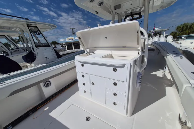 Slide: The Image of 2026 Regulator 31 boat interior with open storage compartments under a clear blue sky. - 14