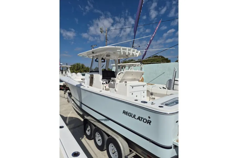 Slide: The Image of 2026 Regulator 31 boat on trailer under clear blue sky. - 17