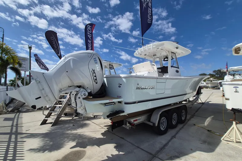Slide: The Image of 2026 Regulator 31 boat with Yamaha engines on a trailer, displayed outdoors. - 19