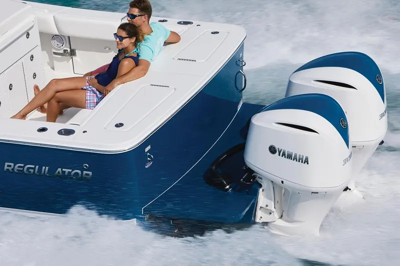 Slide: The Image of 2026 Regulator 31 boat displayed outdoors with palm trees and flags in the background. - 3