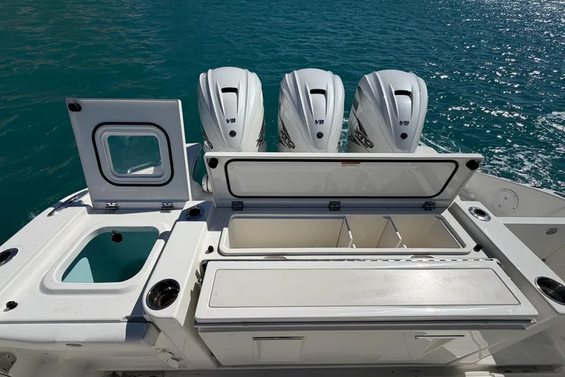 Slide: The Image of 2021 Pursuit S 378 Sport boat with open storage compartments and triple outboard engines. - 16