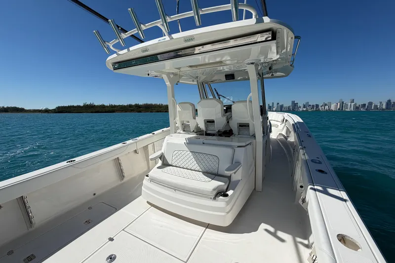 Slide: The Image of 2021 Pursuit S 378 Sport boat on blue water with city skyline in background. - 18