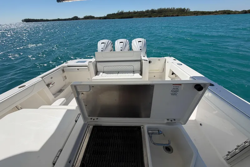 Slide: The Image of 2021 Pursuit S 378 Sport boat with open deck and triple engines on blue water. - 19