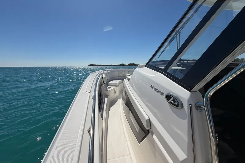 Slide: The Image of 2021 Pursuit S 378 Sport boat cruising on clear blue water under a sunny sky. - 25
