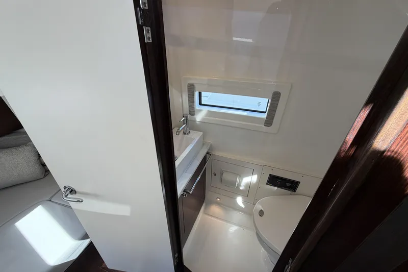 Slide: The Image of 2021 Pursuit S 378 Sport boat interior bathroom with sink, toilet, and window. - 39