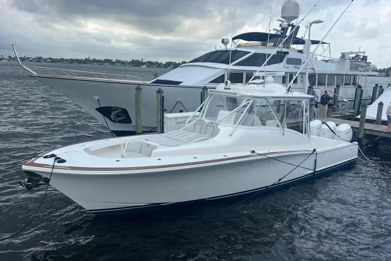 Slide: The Image of 2026 Albemarle 45 Carolinian Fisharound Express docked beside a larger yacht. - 2