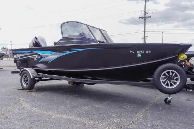 The Image of 2025 G3 Angler V178 F boat on trailer, black with blue accents, parked outdoors. - 1