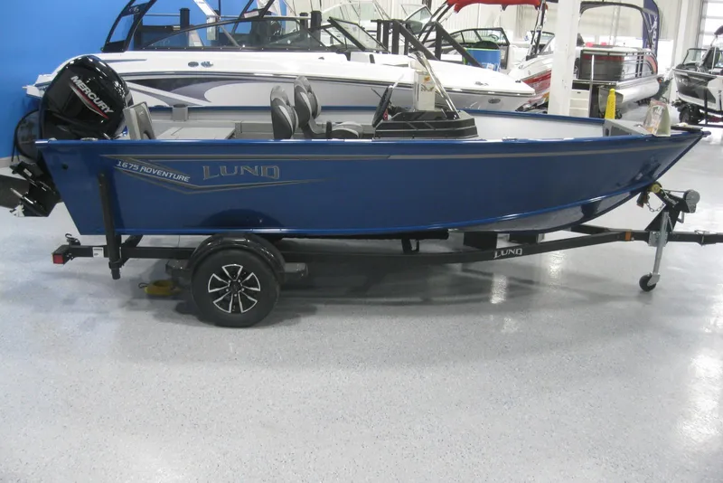 The Image of 2025 Lund 1675 Adventure SS boat on trailer, blue exterior, side view. - 0