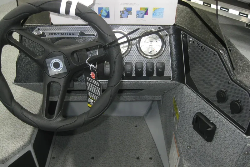 Slide: The Image of 2025 Lund 1675 Adventure SS boat interior with steering wheel and control panel. - 12