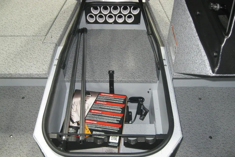 Slide: The Image of 2025 Lund 1675 Adventure SS boat interior with gray carpeted deck and storage compartments. - 14