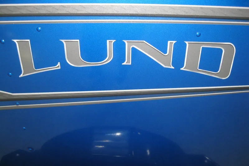 Slide: The Image of 2025 Lund 1675 Adventure SS boat in showroom, blue exterior, modern design. - 2