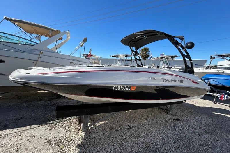 The Image of 2017 Tahoe 2150 boat on display, sleek design, parked on gravel lot. - 1