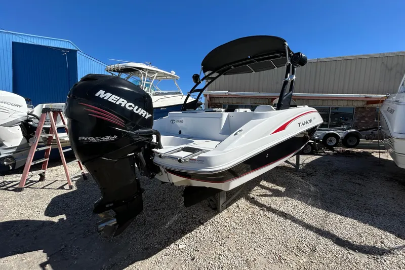 Slide: The Image of 2017 Tahoe 2150 boat with Mercury engine, parked outdoors on gravel. - 3