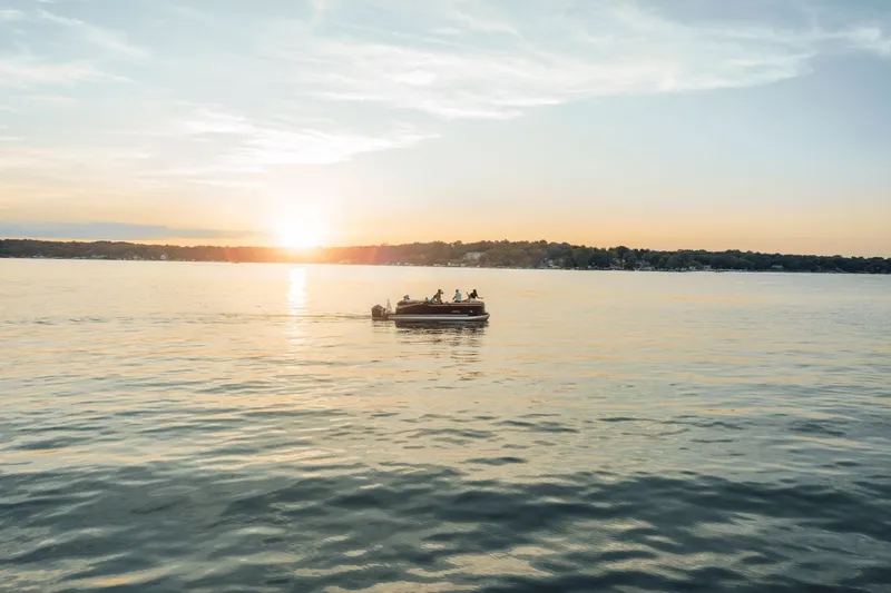 Slide: The Image of 2026 Harris Cruiser 230 on a calm lake at sunset. - 19