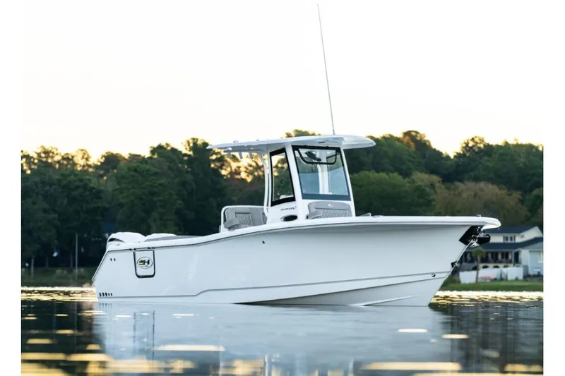 Slide: The Image of 2026 Sea Hunt Ultra 275 Coffin Box boat on calm water at sunset. - 1