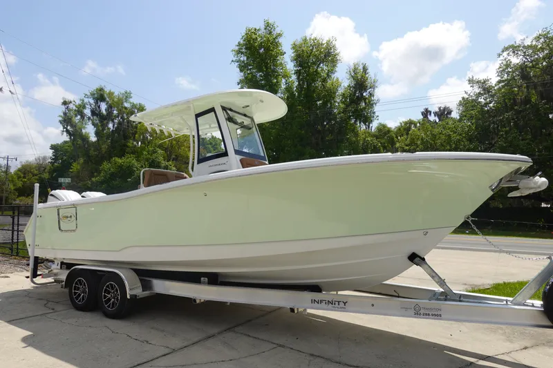 Slide: The Image of 2026 Sea Hunt Ultra 275 Coffin Box boat with brown cushioned seating and dual engines. - 5