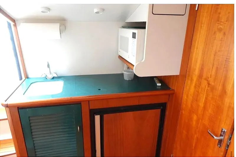 Slide: The Image of 1997 Pursuit 3000 Express interior with TV, kitchenette, and wooden cabinetry. - 14