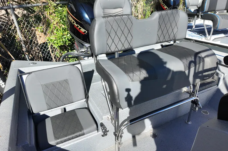 Slide: The Image of 2026 Xpress H20B Bay boat interior with gray seating and motor in background. - 12