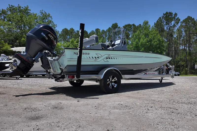 Slide: The Image of 2026 Xpress H20B Bay boat on trailer with Yamaha engine, parked outdoors. - 2