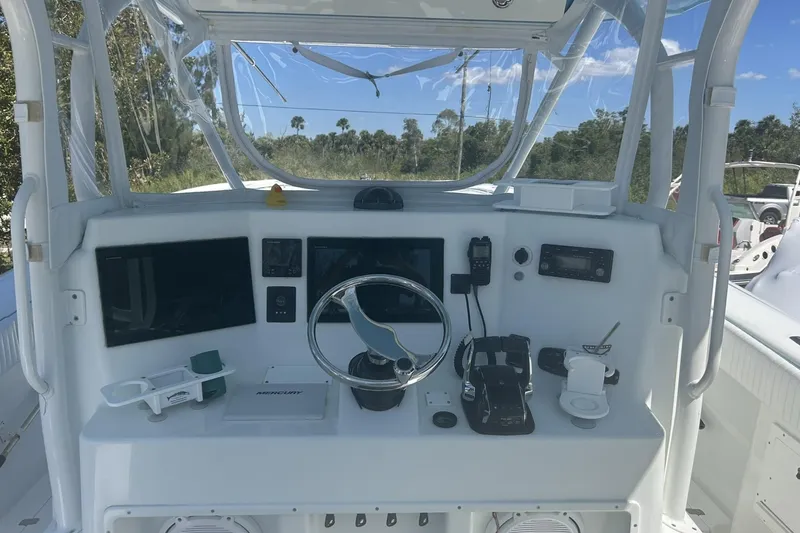 Slide: The Image of 2009 Yellowfin 42 Offshore boat helm with steering wheel, controls, and navigation equipment. - 5