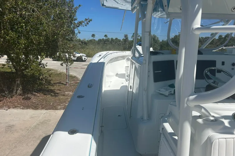 Slide: The Image of 2009 Yellowfin 42 Offshore boat interior with steering wheel and console, parked outdoors. - 8