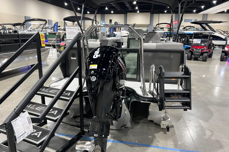 Slide: The Image of 2026 Alera A22Q boat with Mercury engine displayed at an indoor boat show. - 18