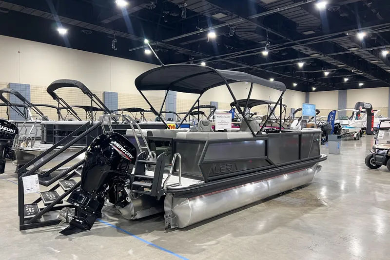 Slide: The Image of 2026 Alera A22Q pontoon boat displayed indoors with Mercury outboard motor. - 4