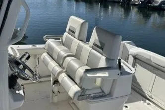 Slide: The Image of 2013 Everglades 275 Center Console boat interior with cushioned seating and steering wheel. - 4
