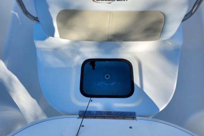 Slide: The Image of Bulls Bay 2000 boat interior, featuring a livewell and cushioned seating, 2022 model. - 16