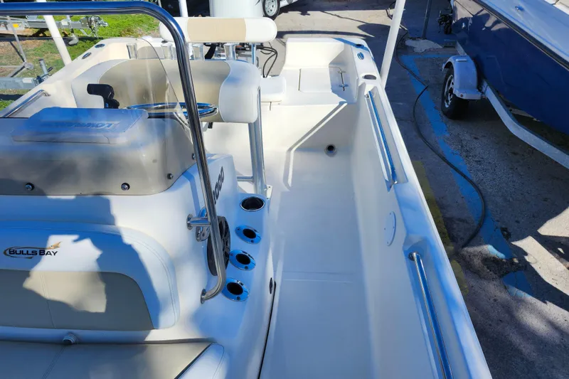 Slide: The Image of 2022 Bulls Bay 2000 boat interior with seating and console, parked on a trailer. - 19
