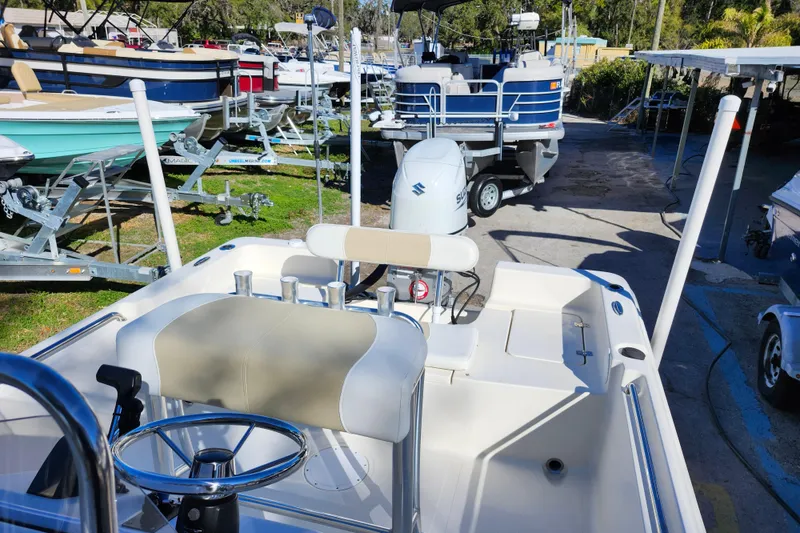 Slide: The Image of 2022 Bulls Bay 2000 boat interior with steering wheel and seating, surrounded by other boats. - 26