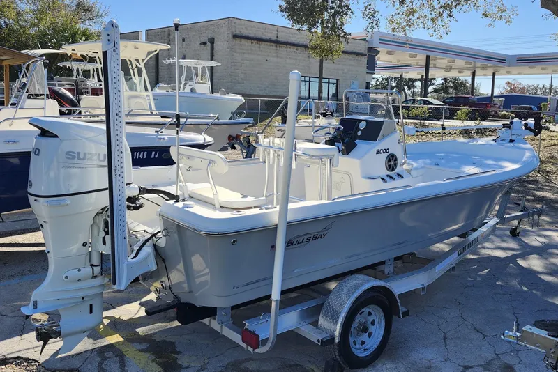 Slide: The Image of 2022 Bulls Bay 2000 boat with Suzuki engine on a trailer in a marina. - 9