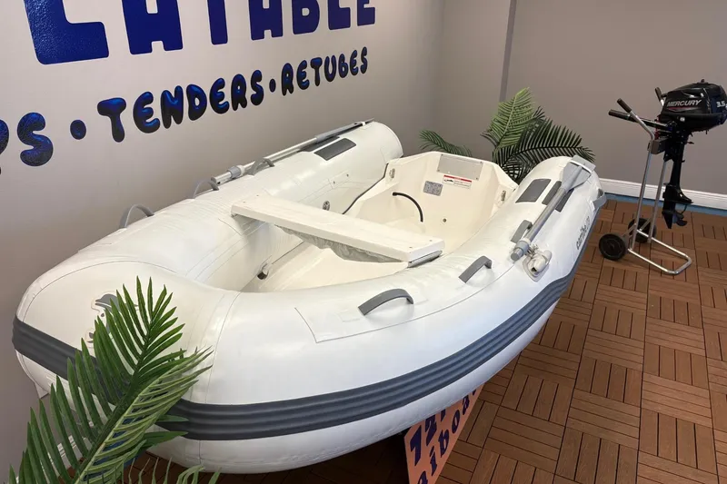 Slide: The Image of Inflatable Caribe L-9 boat, 2025 model, displayed indoors with outboard motor nearby. - 17