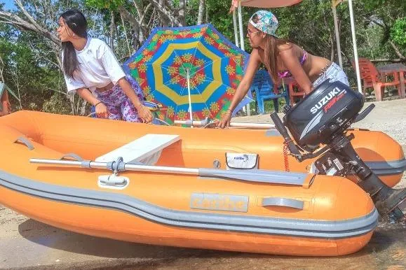 Slide: The Image of Two people with an orange Caribe L-9 inflatable boat, 2025 model, on a sunny beach. - 19