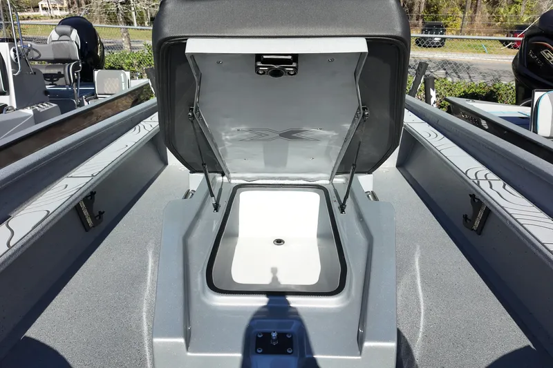 Slide: The Image of 2026 Xpress X23B Bay Lounge boat interior with open storage compartment. - 12
