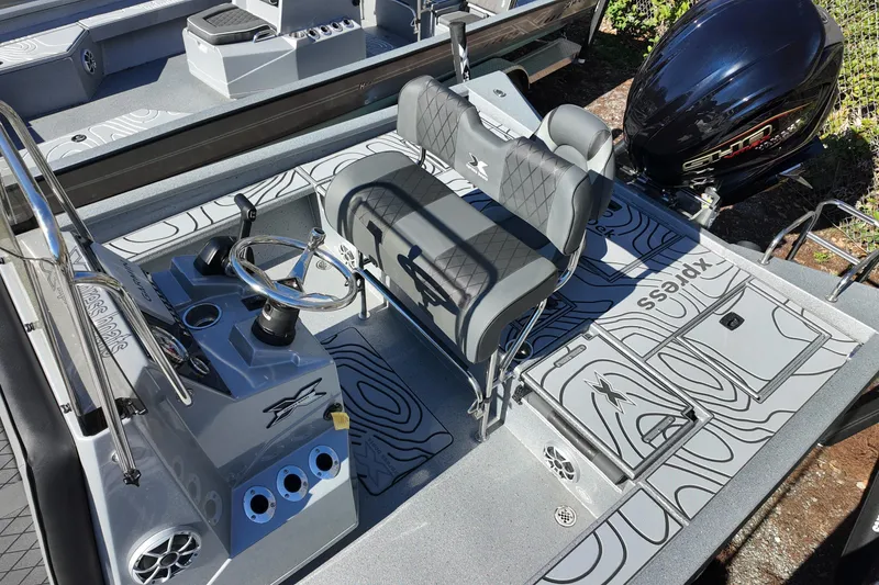 Slide: The Image of 2026 Xpress X23B Bay Lounge boat interior with steering console and seating. - 13