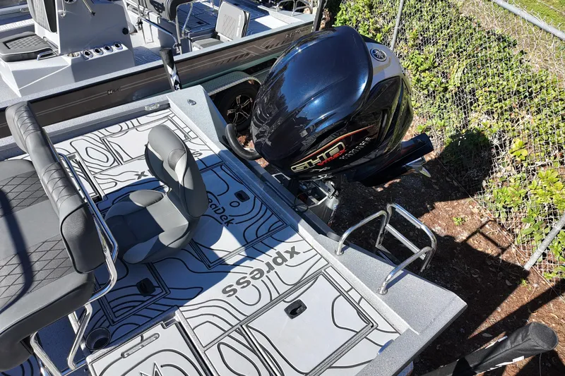 Slide: The Image of 2026 Xpress X23B Bay Lounge boat with sleek seating and powerful outboard motor. - 14