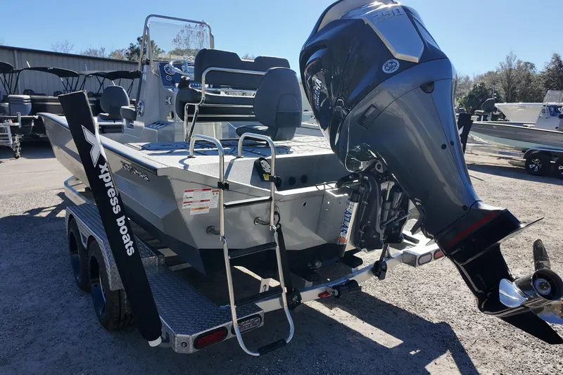 Slide: The Image of 2026 Xpress X23B Bay Lounge boat with powerful outboard motor on trailer. - 16