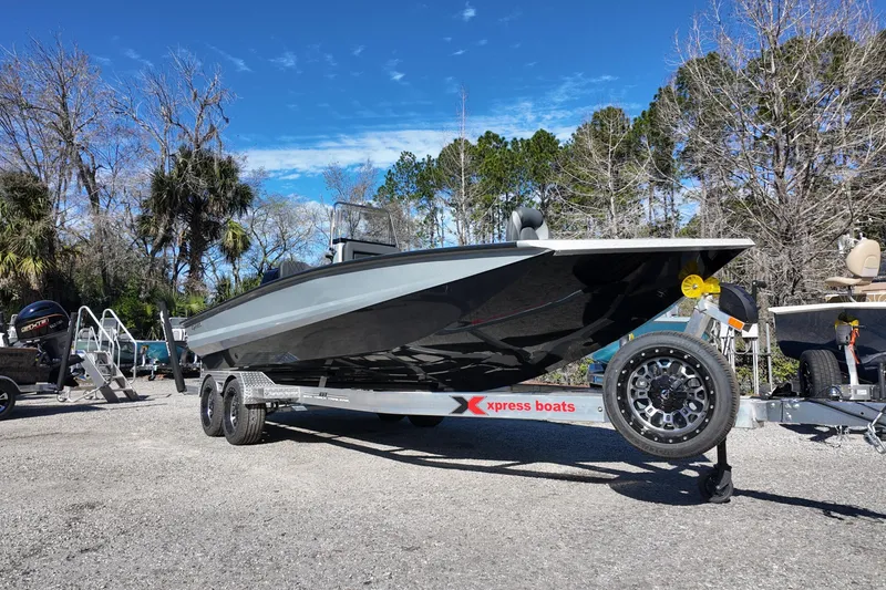 Slide: The Image of 2026 Xpress X23B Bay Lounge boat on trailer, parked outdoors. - 2