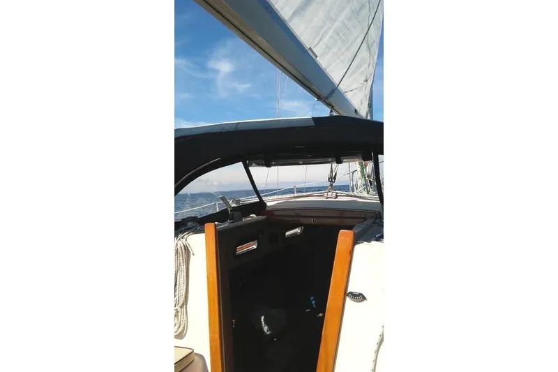 Slide: The Image of 1988 Island Packet 27 sailboat on open water, view from cockpit. - 4