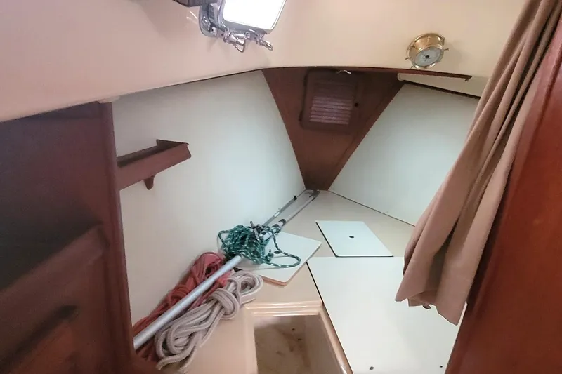 Slide: The Image of 1988 Island Packet 27 sailboat interior with ropes and storage compartments. - 16