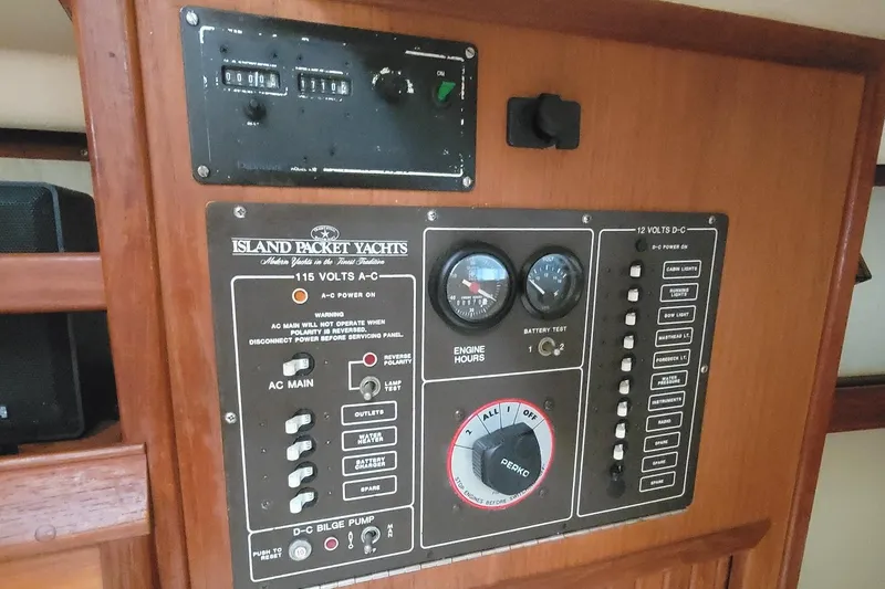 Slide: The Image of Electrical control panel of a 1988 Island Packet 27 yacht, featuring AC and DC systems. - 21
