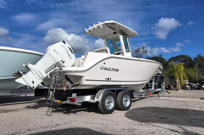 Slide: The Image of 2026 Sailfish 232 CC boat on trailer with Suzuki outboard motor, parked outdoors. - 3