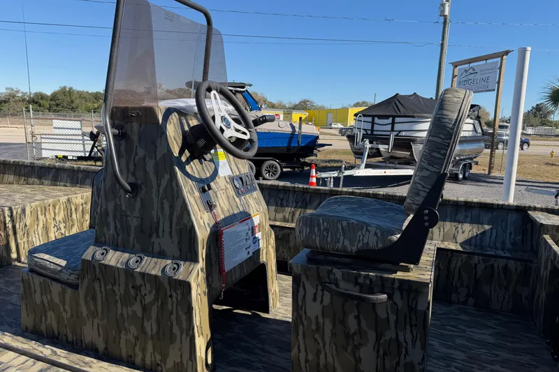 Slide: The Image of 2026 Smoker Craft Sportsman 1866 boat interior with camouflage design and steering console. - 10