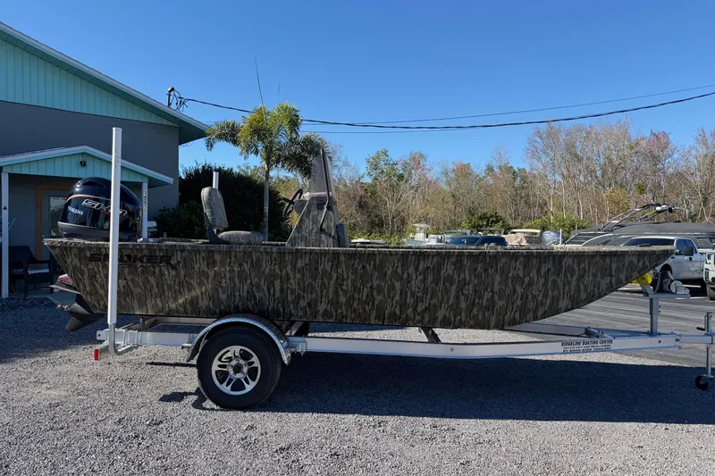 Slide: The Image of 2026 Smoker Craft Sportsman 1866 boat on trailer, camo design, parked outdoors. - 5