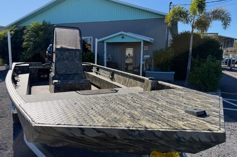 Slide: The Image of 2026 Smoker Craft Sportsman 1866 boat with camouflage design, parked outdoors. - 8